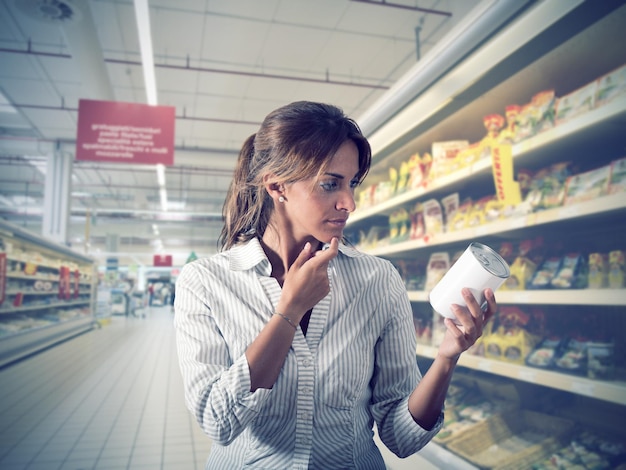 A concerned shopper looking at labels in a grocery store, with a blurred background of various food products, highlighting the confusion and potential anxiety during a food recall.